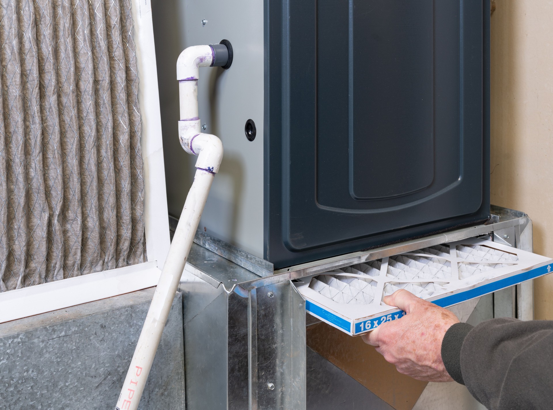 Man replacing dirty furnace filter in home