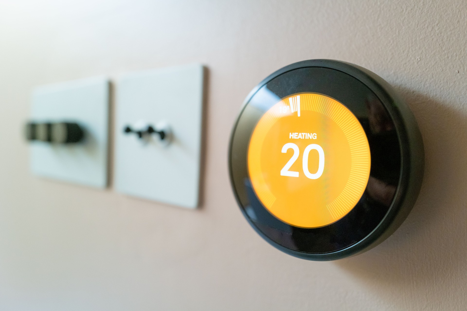 Modern smart thermostat on wall at home